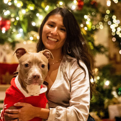 Young woman sitting with a brown pitbull dog